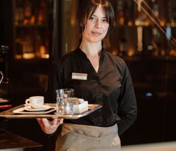Eine Servicekraft serviert Kaffee