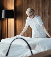 Eine Frau bereitet das Bett vor