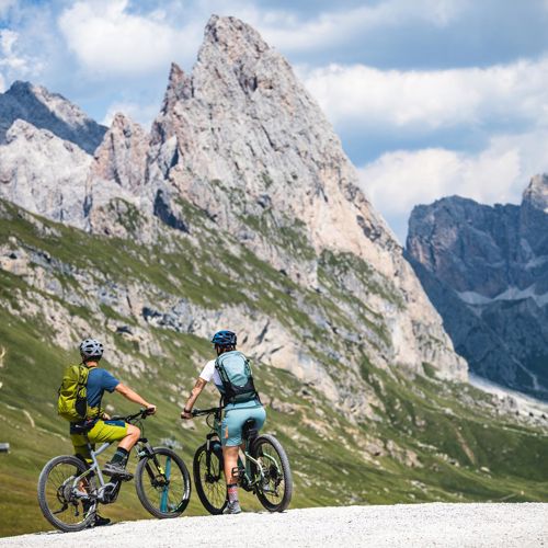 Due ciclisti si godono la vista sulle montagne