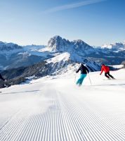 Three people are skiing in the sciing area Dolomiti Superski