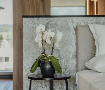 Eine Orchidee steht auf einem Tisch neben dem Bett