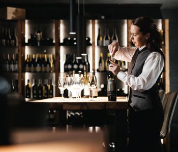 Eine Frau öffnet eine Flasche Wein