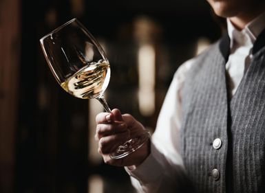 Eine Frau hält ein Glas Weißwein in der Hand