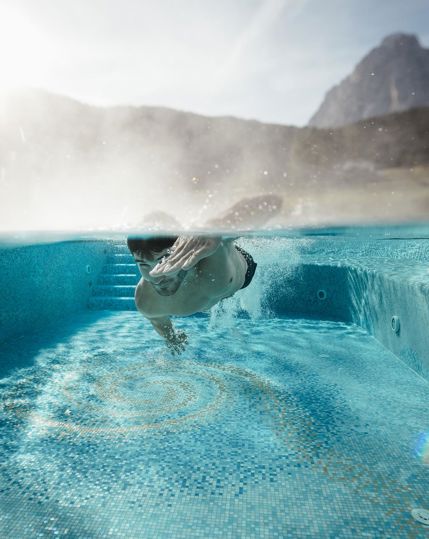 A man is diving in our outdoor pool with mountain view