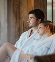 Ein Mann und eine Frau liegen auf einer Liege im Spa Bereich