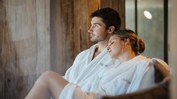 Ein Mann und eine Frau liegen auf einer Liege im Spa Bereich