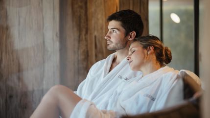 Ein Mann und eine Frau liegen auf einer Liege im Spa Bereich