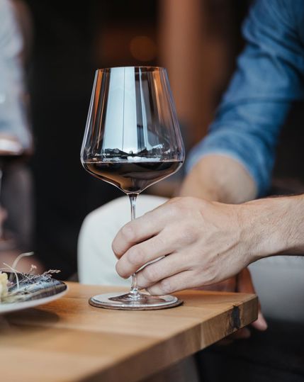 A couple is enjoying to glasses of red wine and a cheese selection