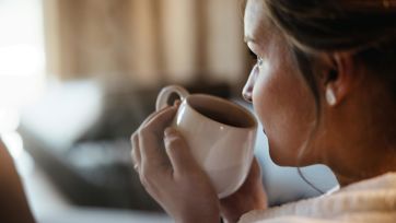 A woman is drinking a cup of tea