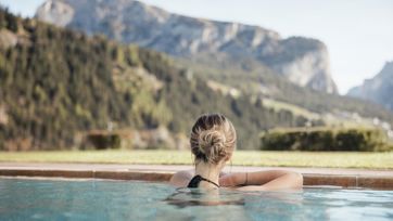 A woman is enjoying the mountain view from our outdoor pool
