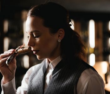 Eine Frau prüft den Duft eines Weinkorkens