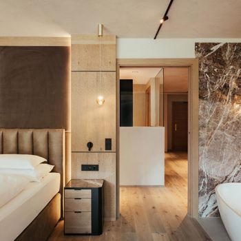 Eines der Schlafzimmer mit Doppelbett und freistehender Badewanne